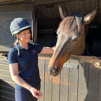A portrait of Jilly Foster smiling beside a horse