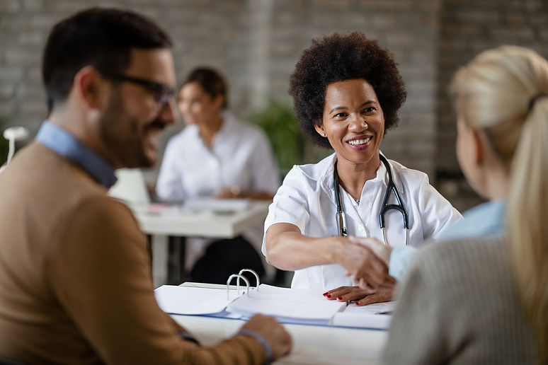 happy-african-american-doctor-shaking-hands-with-couple-after-medical-appointment-clinic.j