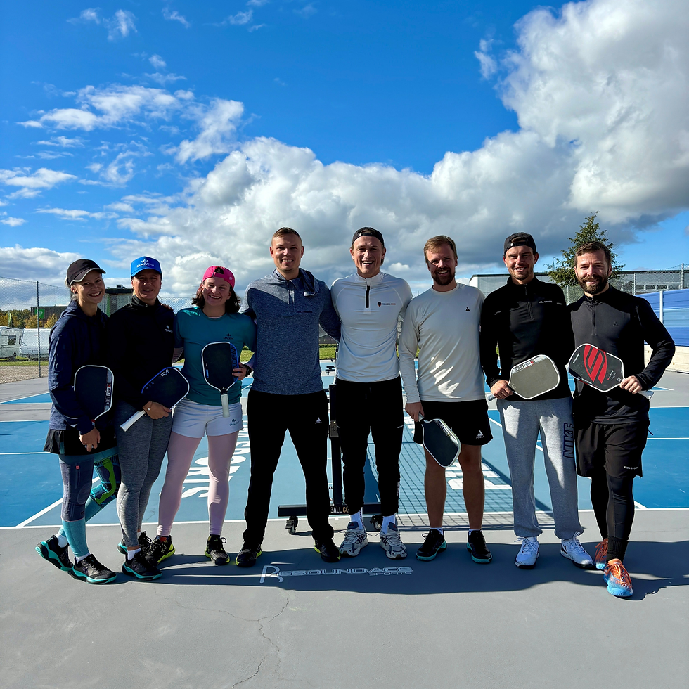 Die fünf Pickleball-Spieler Carolin Nothnagel, Karolina Owczarek, Felix Grunert, Basti Grau und Dominik Regler stehen gemeinsam mit René Zeltner, Inhaber der Piba-Pickleball-Plätze in Neumarkt, in einer Reihe auf dem Court. Alle halten ihre Schläger in der Hand, lächeln in die Kamera und trainieren bei sonnigem Pickleball-Wetter.