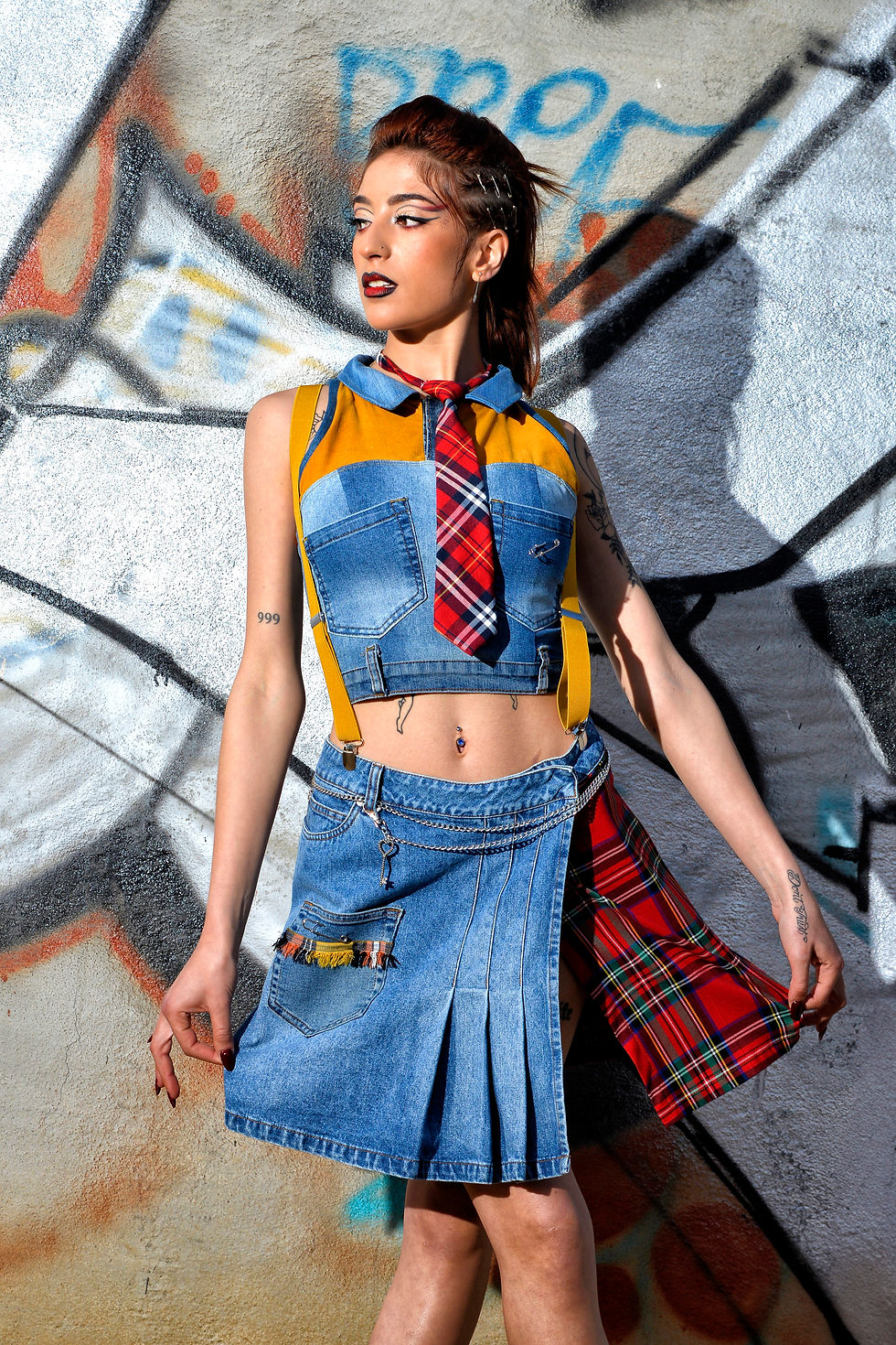 Completo in stile British Street College: top all'americana abbinato a gonna a pieghe in jeans con inserti scozzesi e tasche