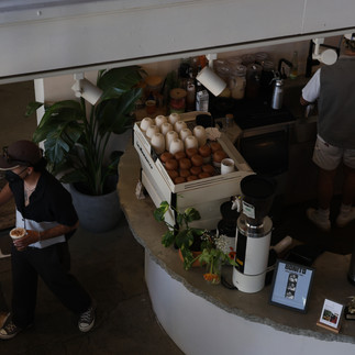 Wide view of latino coffee shop bar with customer holding two take away coffees.