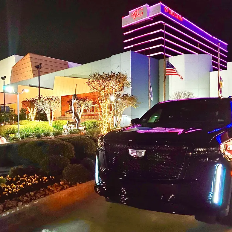 Classy black Cadillac Escalade outside of a casino.  The mood appears to be VIPs an high rollers on a casino excursion.