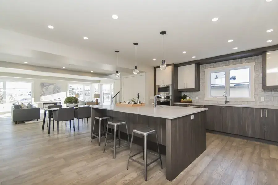 Modern open floor plan kitchen with large island breakfast bar seamlessly connecting to the living area.