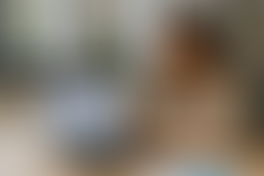 A young professional woman with glasses types on a laptop in a bright modern office. The laptop screen displays a presentation slide titled “Mastering Content Marketing for Technical Solutions,” featuring charts, icons, and strategy points. Potted plants and shelves decorate the workspace, creating a clean, professional setting that emphasizes the blend of technical expertise and marketing strategy.