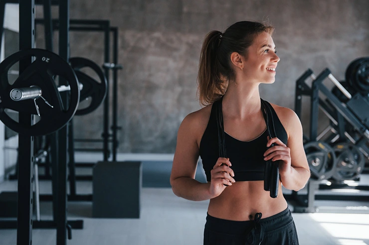 Woman working out with barbell in gym