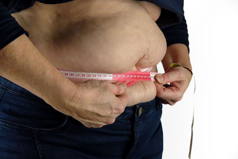 Man measuring his belly. Featured image for “5 Reasons You Aren’t Losing Belly Fat”