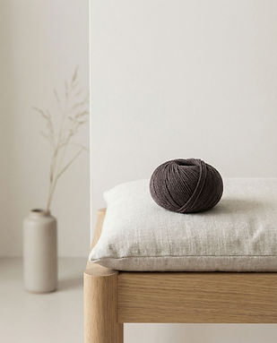 Ein Knäuel Wolle liegt auf einer Bank