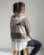 Rückansicht der BARISTA Jacke mit Kapuze, Farbflächen, Streifenpartie und weißer Bluse darunter.