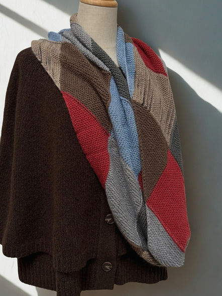 Fertig gestrickter Riti Vibes Loop, zweimal gelegt, zeigt die Struktur aus geneigten Quadraten und Abschlussdreiecken