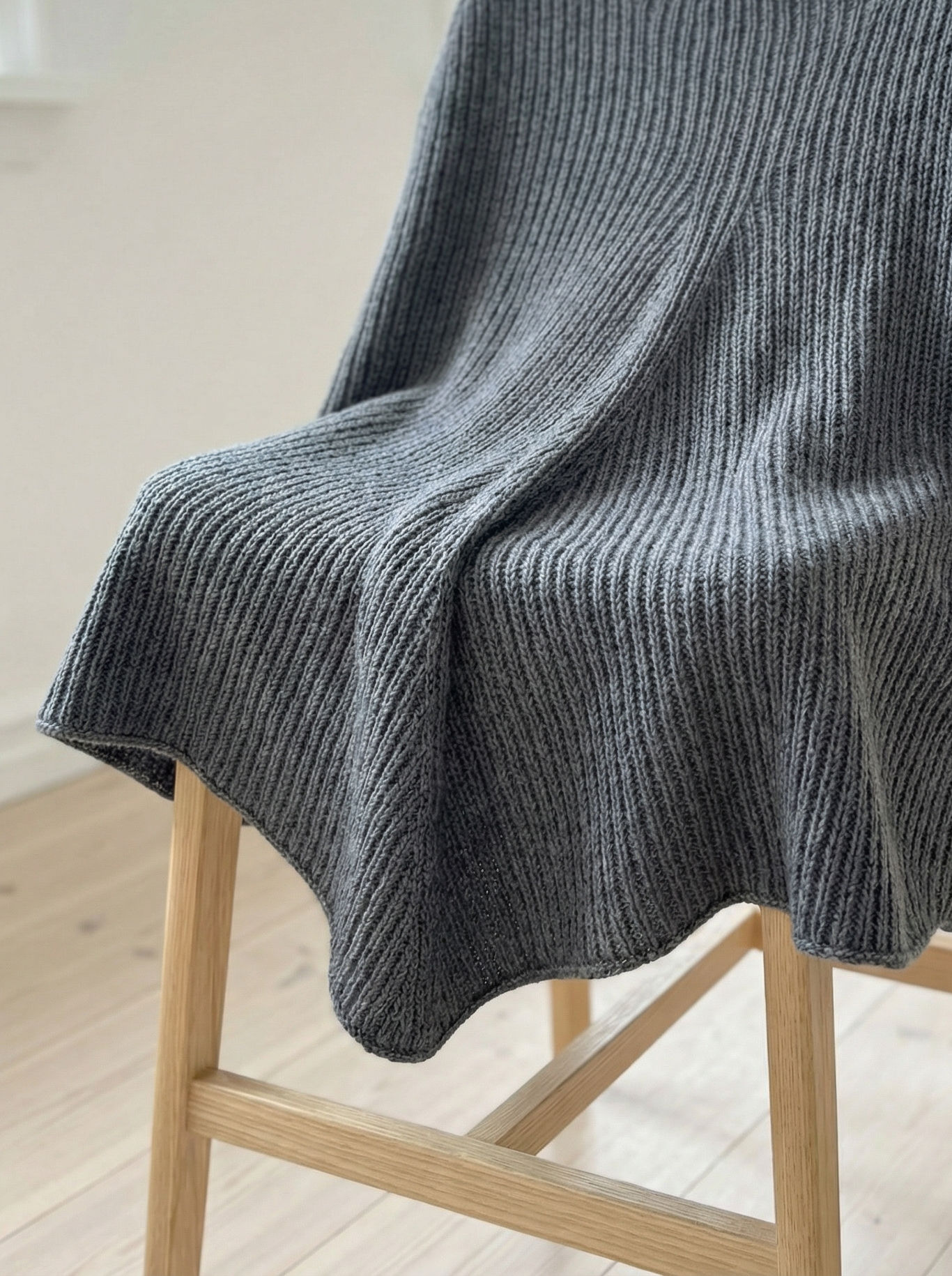 Detailaufnahme des Leila Ponchos mit gleichmäßigem Rechts-Links-Muster und feinem Maschenbild