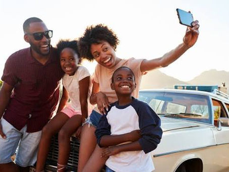 A family safely enjoying a summer road trip adventure by the ocean, illustrating the importance of vehicle travel readiness.