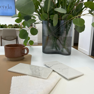 A white desk with a brown coffee mug and plant decorations