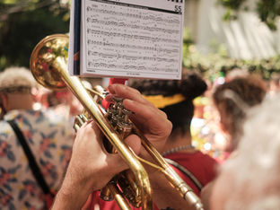 foto de um caderno de partituras e alguém tocando trombone