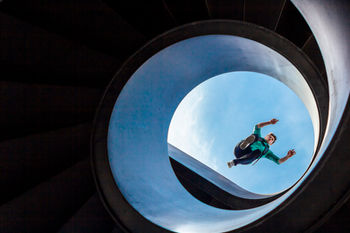 swiss recycling campaign photography by Omid Taslimi. Chris Harmat jumping over a circle staircase in Basel.

