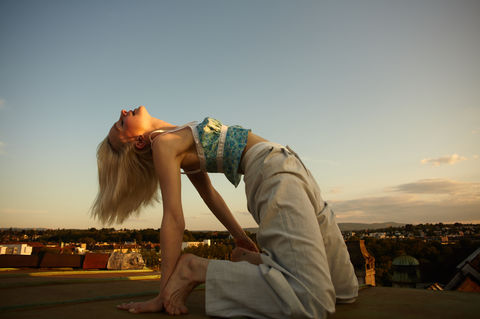 girl makes a bridge on a rooftop