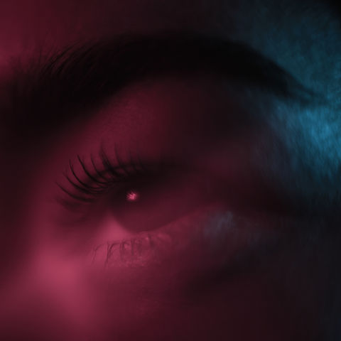 super close up eye of a girl with red and blue light, low key studio photography Omid Taslimi Photography
