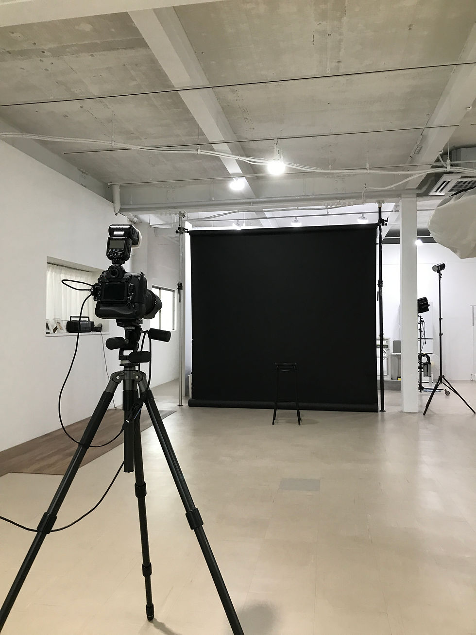 Eye-level view of a spacious photography studio with lighting equipment