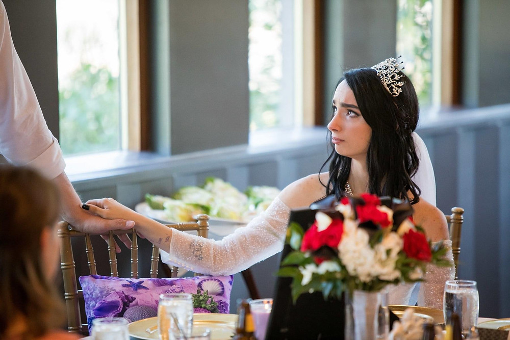 bride with mother's memorial pillow on designated wedding reception chair
