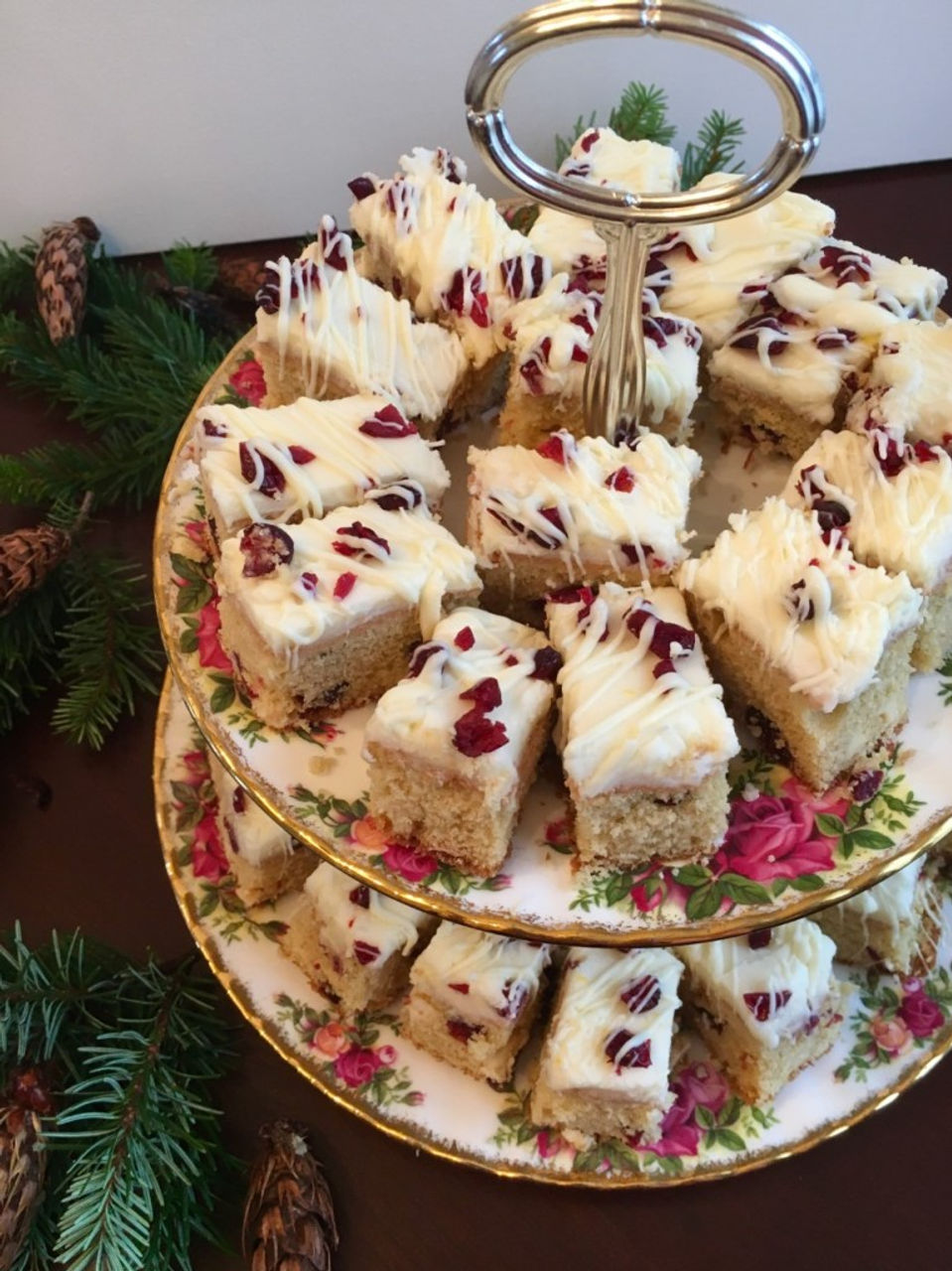 Cranberry bliss bars arranged on a 2 tiered platter for a party.