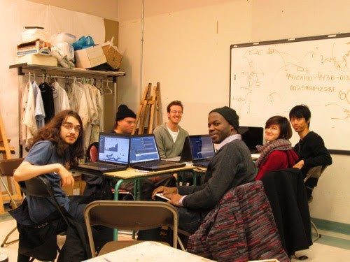 Photo montrant cinq jeunes et l'animateur de l'atelier sont assis autour d'une table avec des ordinateurs.
