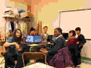 Photo montrant cinq jeunes et l'animateur de l'atelier sont assis autour d'une table avec des ordinateurs.