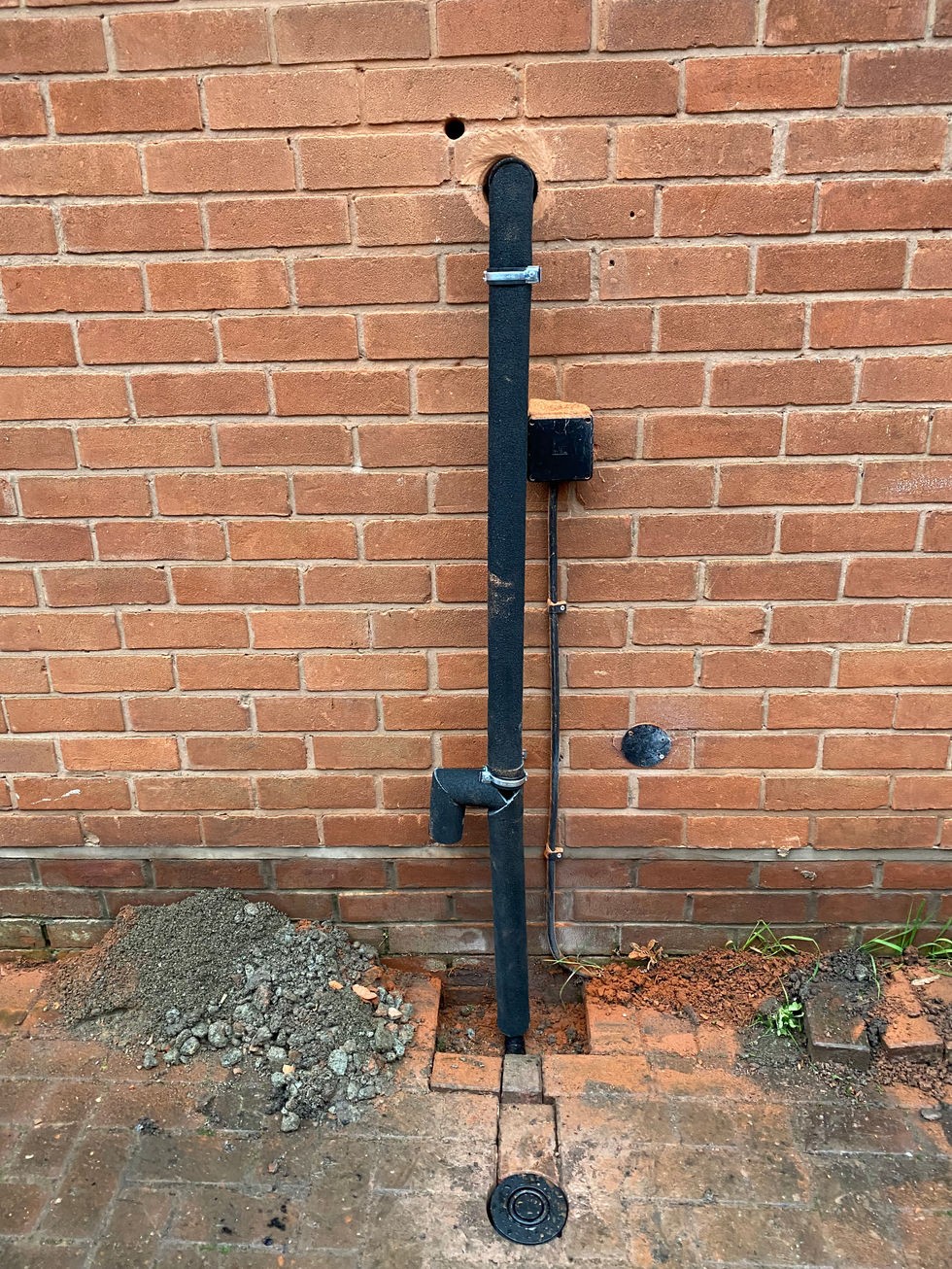 a black pipe is attached to a brick wall