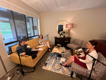 Three women recording a podcast in a comfortable studio.