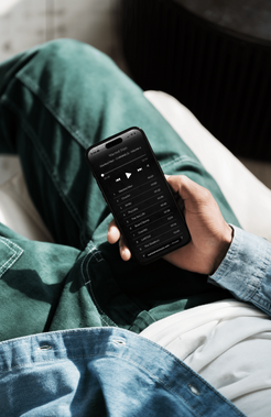 Person holding smartphone with Wanted Man Music playlist