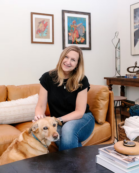 Woman from Bieze Design smiling on a couch with her dog.