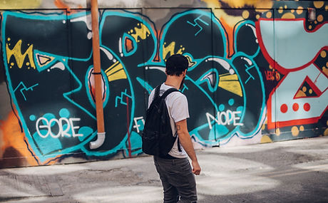 Man Looking at Colorful Graffiti Wall