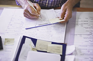 A zoomed in view of a desk with various papers and notes on.