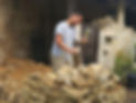 Jérémy LEPIECE taille la pierre pour reconstruire un mur en moellon.