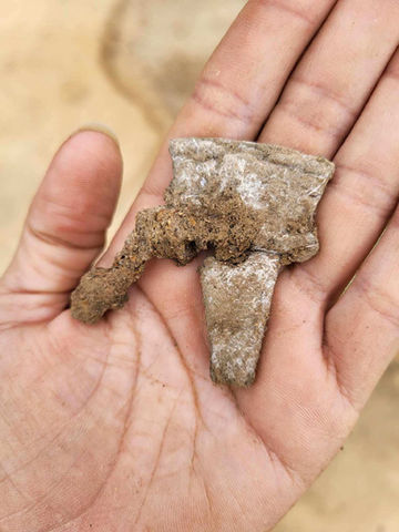 Hand holding a lead powder flask spout