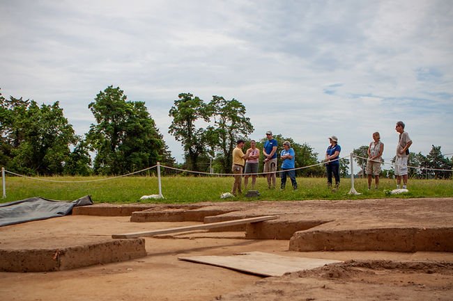 Tour guide delivering tour of excavation site to group of visitors