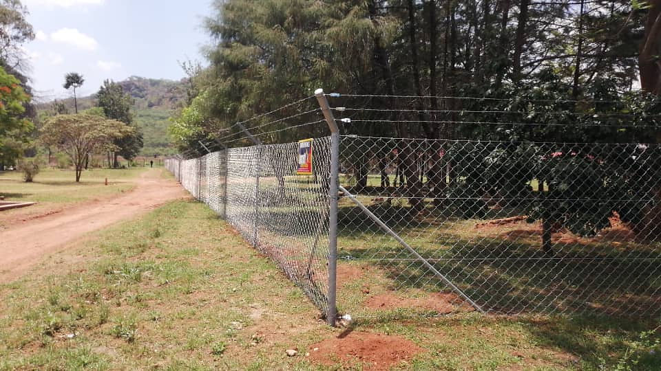 Barrett Electronics Products chain-link fence along a dirt road