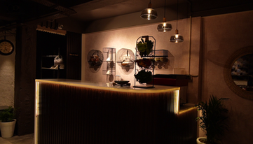 This image shows the interior of the cafe. It captures the counter where we make coffee display the menu. It has a backdrop showcasing the craftfully chosen crockery and cutlery used in the cafe