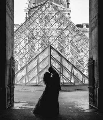 Couple in silhouette in front of the Louvre Pyramid, black-and-white photo