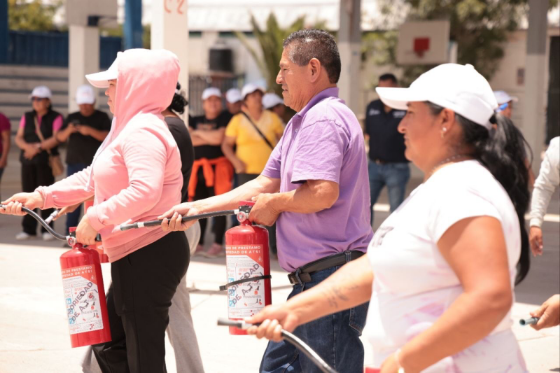 Participantes practican el uso de extintores durante una sesión de formación práctica del programa.