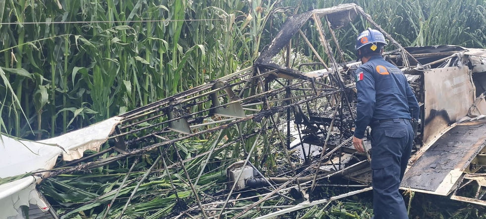 Un rescatista inspecciona los restos de una aeronave accidentada entre campos, asegurando que no haya riesgos adicionales para la población o el entorno.