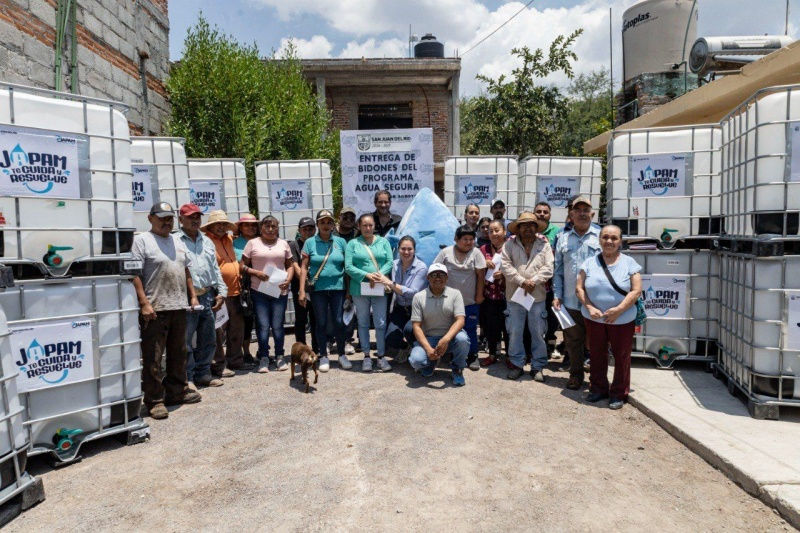 Entrega de bidones del programa "Agua Segura" por parte de la JAPAM, destacando el impacto positivo en la comunidad de La Llave con la presencia de Gilberto Cruz y vecinos beneficiados.