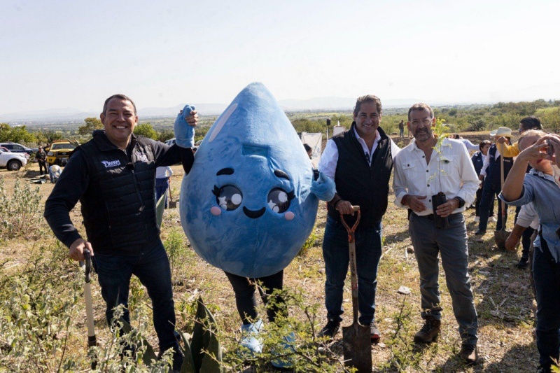 Toño Pérez participa en un evento comunitario para promover la recuperación del acuífero, acompañado de una mascota en forma de gota de agua, simbolizando la importancia de las lluvias en el esfuerzo ambiental.