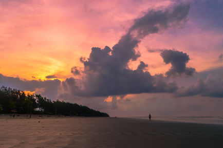 Colorful sunset with clouds over a beach.