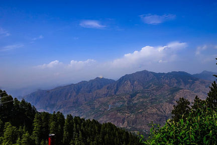 Mountain landscape with blue sky and scattered clouds.