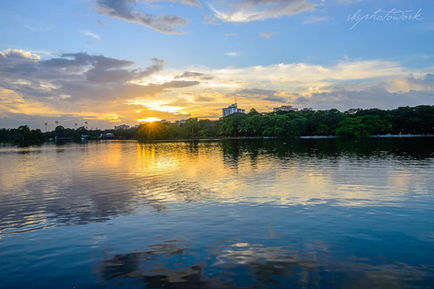 Sunset over a calm lake with trees.