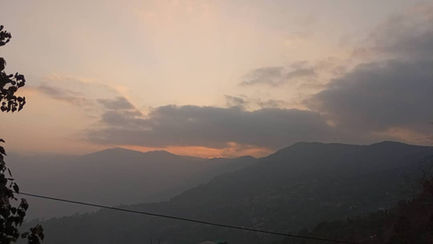 Mountainous landscape with a sunset sky.