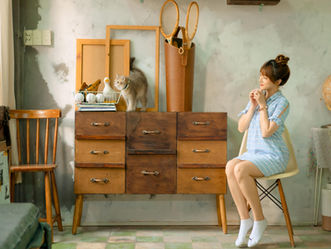 Photo of a woman looking at a cat on a dresser. Photo by Hải Nguyễn on Pexels.