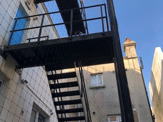 View from under black metal fire escape stairs 