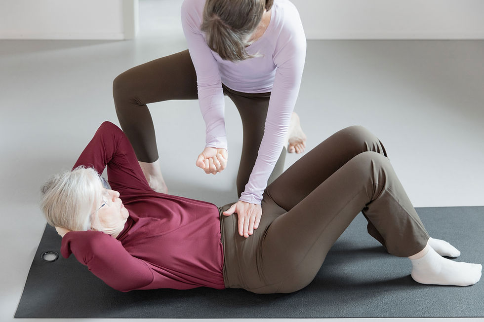 Trainerin leitet gehörlose Teilnehmerin im Pilates-Training der Pilates Stube Zürich an.