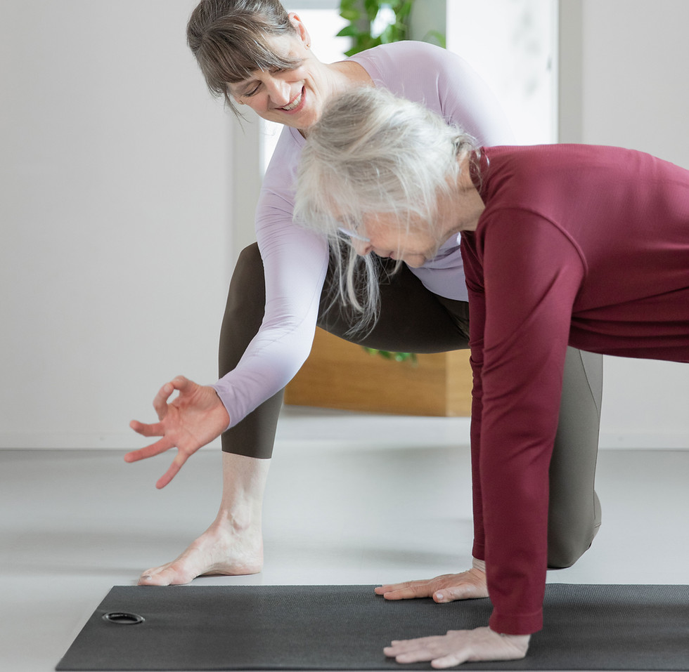 Trainerin unterrichtet eine gehörlose Person im Pilates-Training der Pilates Stube Zürich