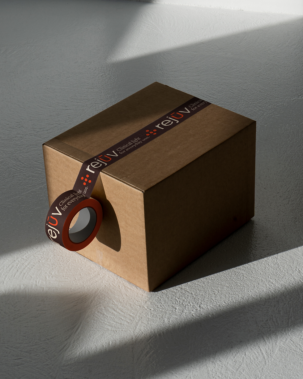 A cardboard shipping box sealed with Rejuv branded tape on a neutral background.